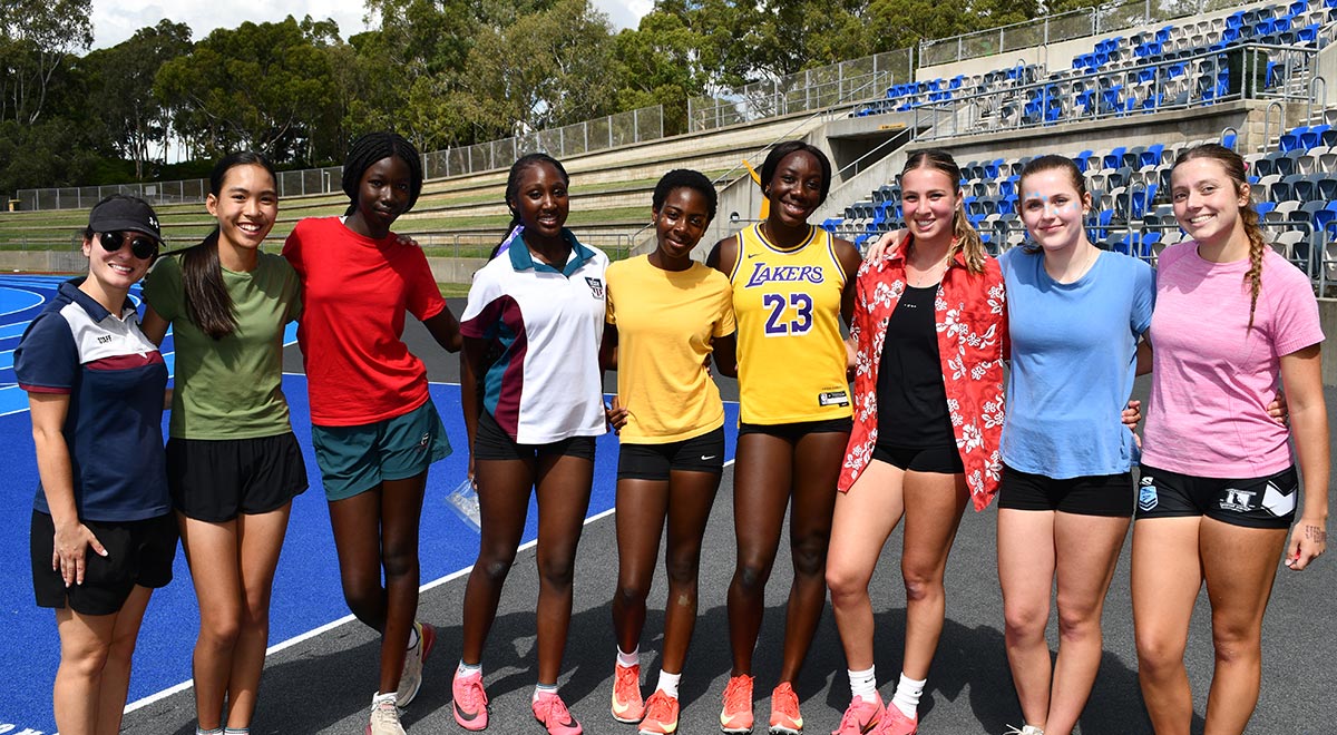 Ms A. Papazoglou, Sports Coordinator, with competitors from the 100m Open Final race
