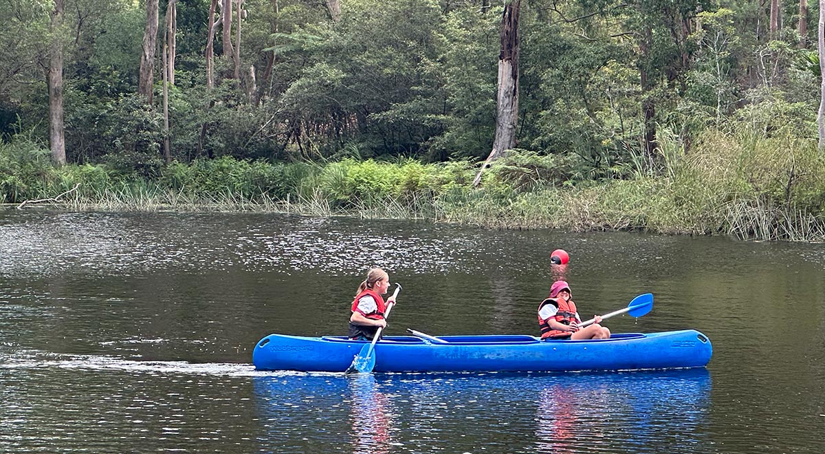 Catherine McAuley Westmead students rowing a boat down a stream
