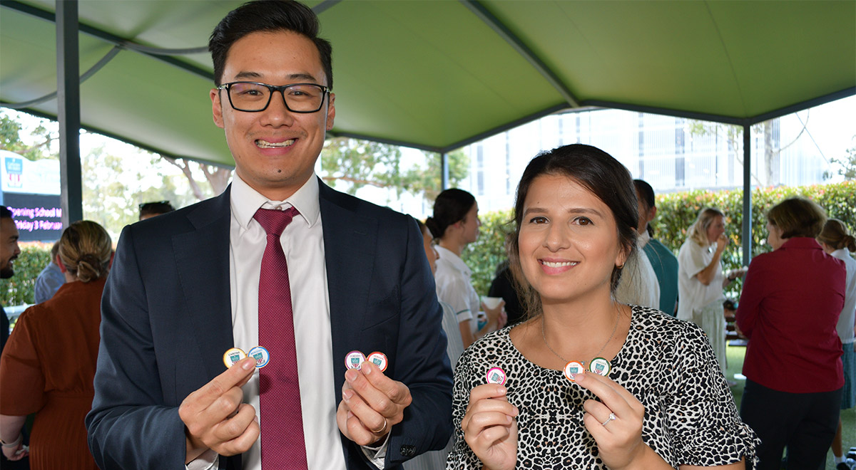 Mr Daniel Nguyen and Ms Sibel Erkan holding the House pins they developed as part of their involvement with the Mercy Formation Program.