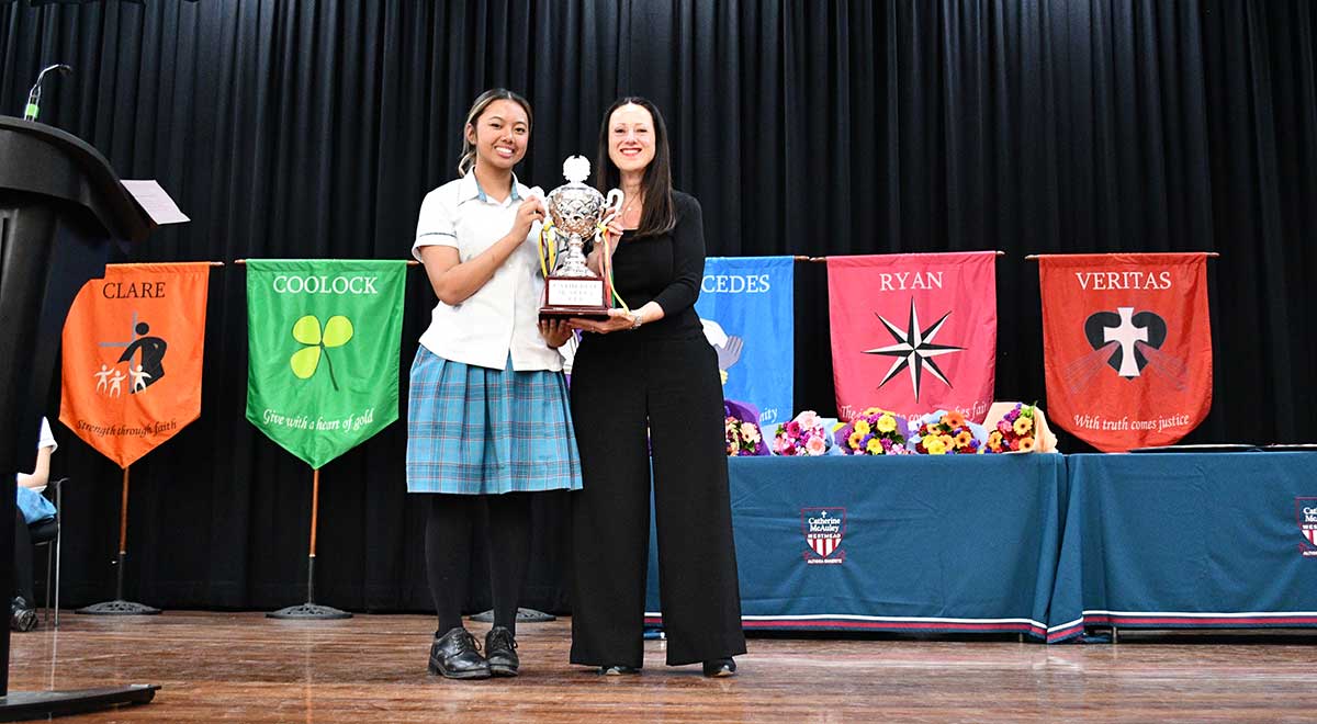 Liz S., Leader of Dobson House, receives the 2023 House Cup on behalf of Dobson House.