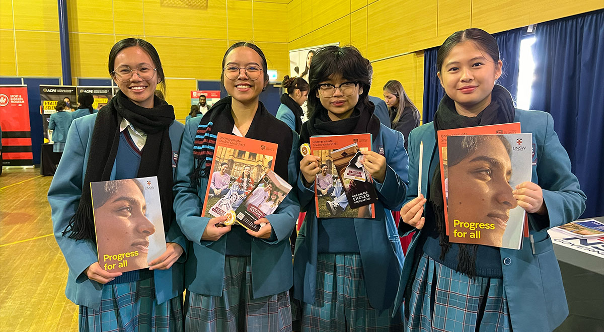 McAuley Westmead students at a careers expo, holding up promotional material