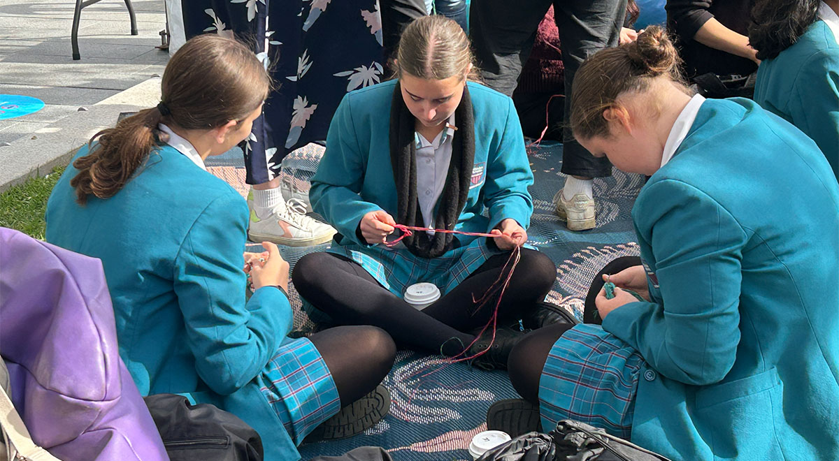 Catherine McAuley Westmead students attend Parramatta Council National Sorry Day event. The students are sitting in a weaving workshop.