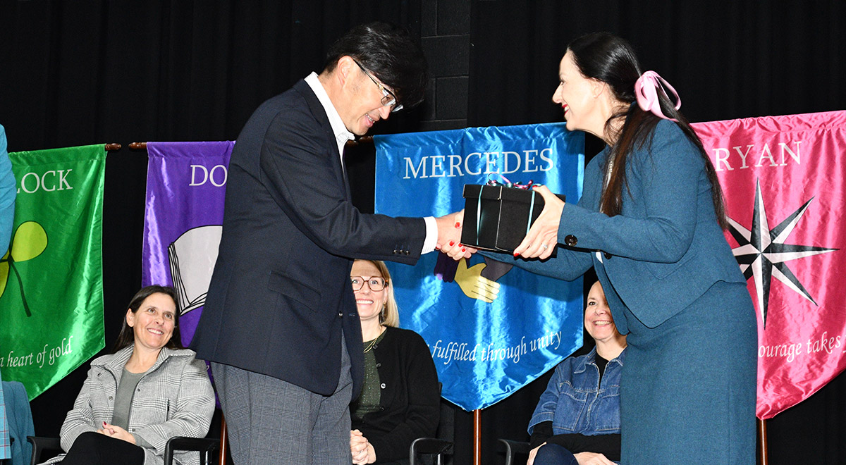 School Principal Mary Refalo presents a gift from the school to visiting teacher Tomohiro Hojo.
