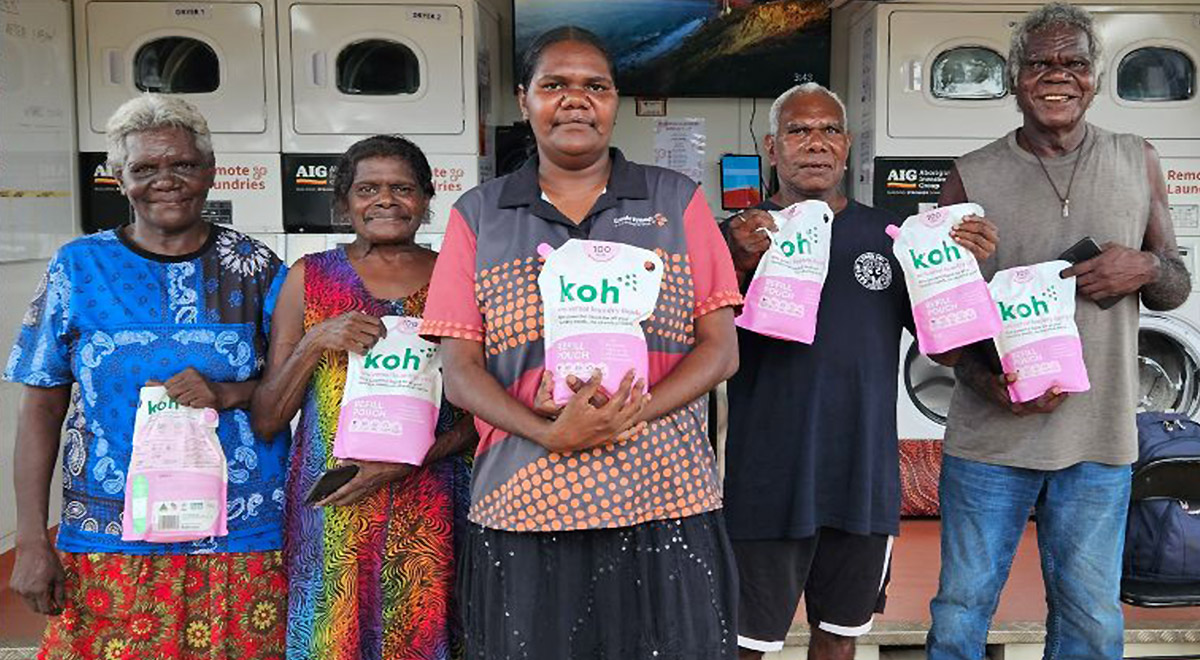 Women and man holding detergent from Remote Laundries project