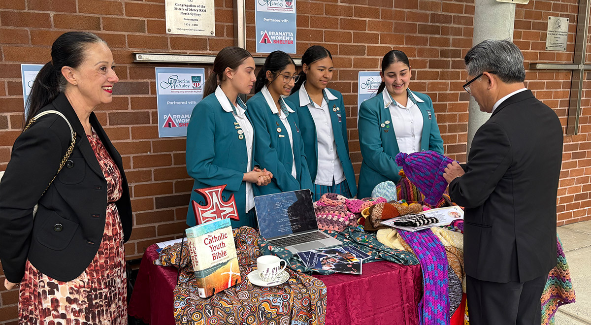 Year 10 students, with Bishop Vincent and Ms Refalo, showcasing the school's work for The Parramatta Women's Shelter.