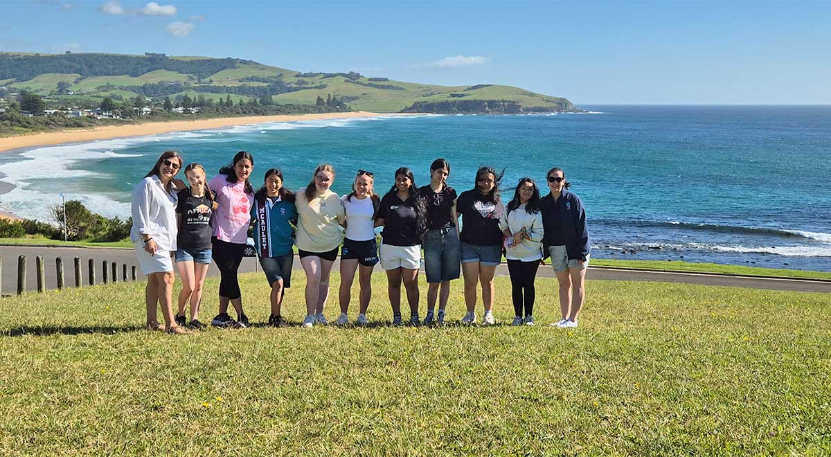 Catherine McAuley Westmead students, from Year 11 Geography, on a trip to the South Coast. The students are standing in front of the ocean.