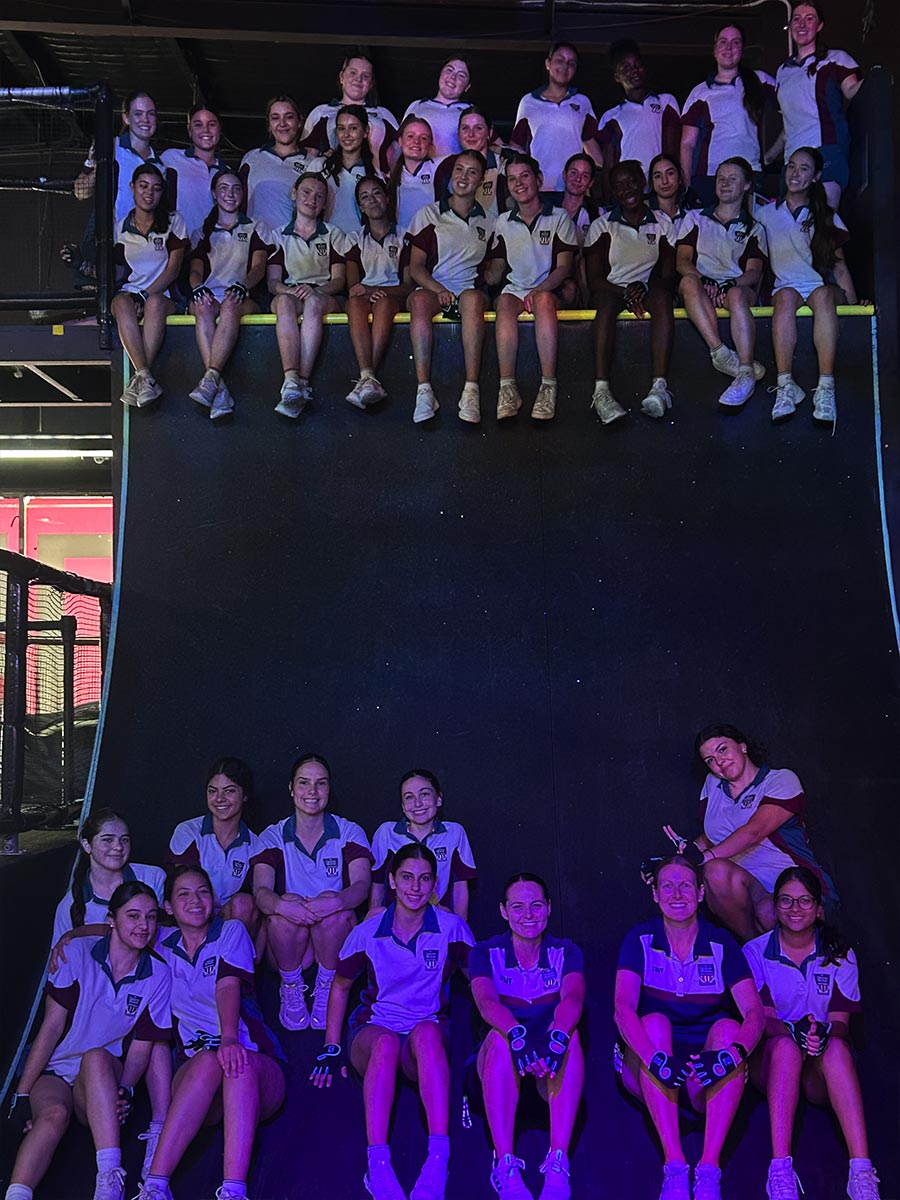 Group photo of Catherine McAuley Westmead students at Tru Ninja Warrior. The students are sitting ontop a ramp.