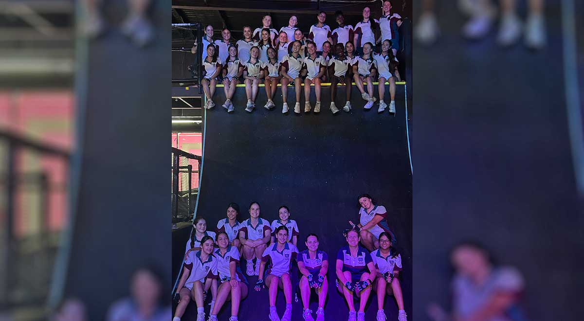 Group photo of Catherine McAuley Westmead students at Tru Ninja Warrior. The students are sitting ontop a ramp.