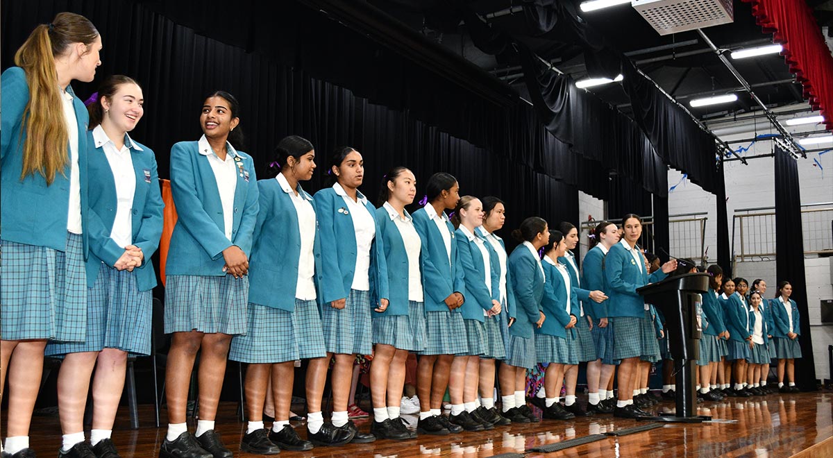 Student leaders leading school song at IWD assembly
