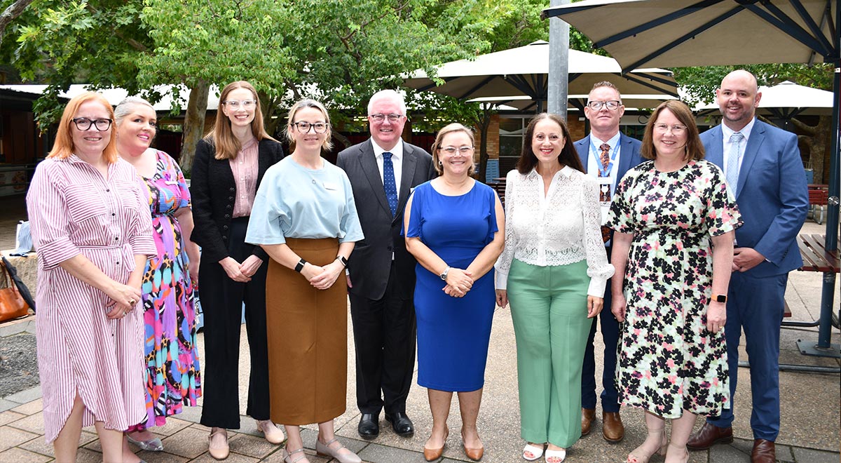 VIP guests at IWD assembly with guest speaker Kirsty Andrews in centre blue dress