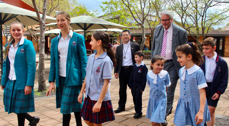 Bishop Vincent Long and CSPD Director walking with students from Catherine McAuley Catholic College Westmead and Mother Teresa Catholic Primary Westmead