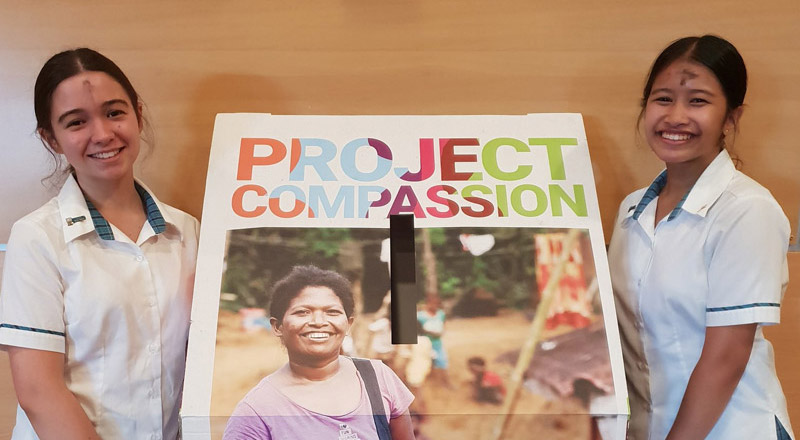 Catherine McAuley Catholic College Westmead students promoting Project Compassion donation box