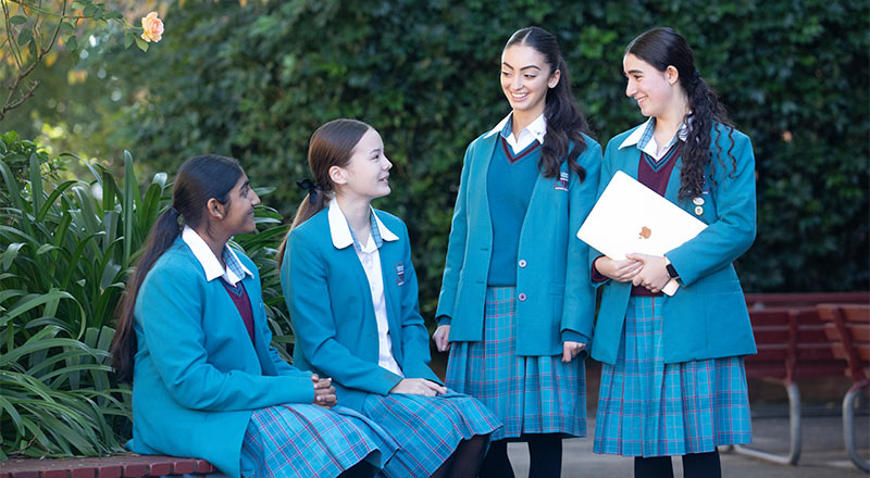 Example of Uniform at Catherine McAuley Westmead. 4 students are outdoors.